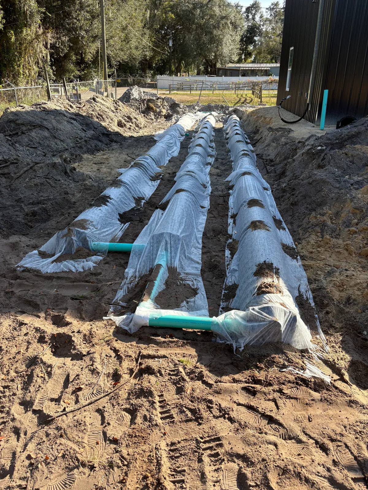 New drain field pipe laid in sandy Polk County soil during restoration
