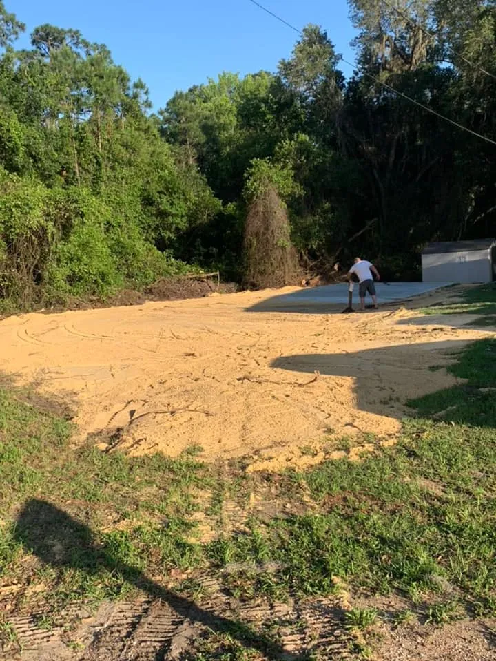 Fresh backfill and graded sand over a repaired drain field in a Haines City back yard